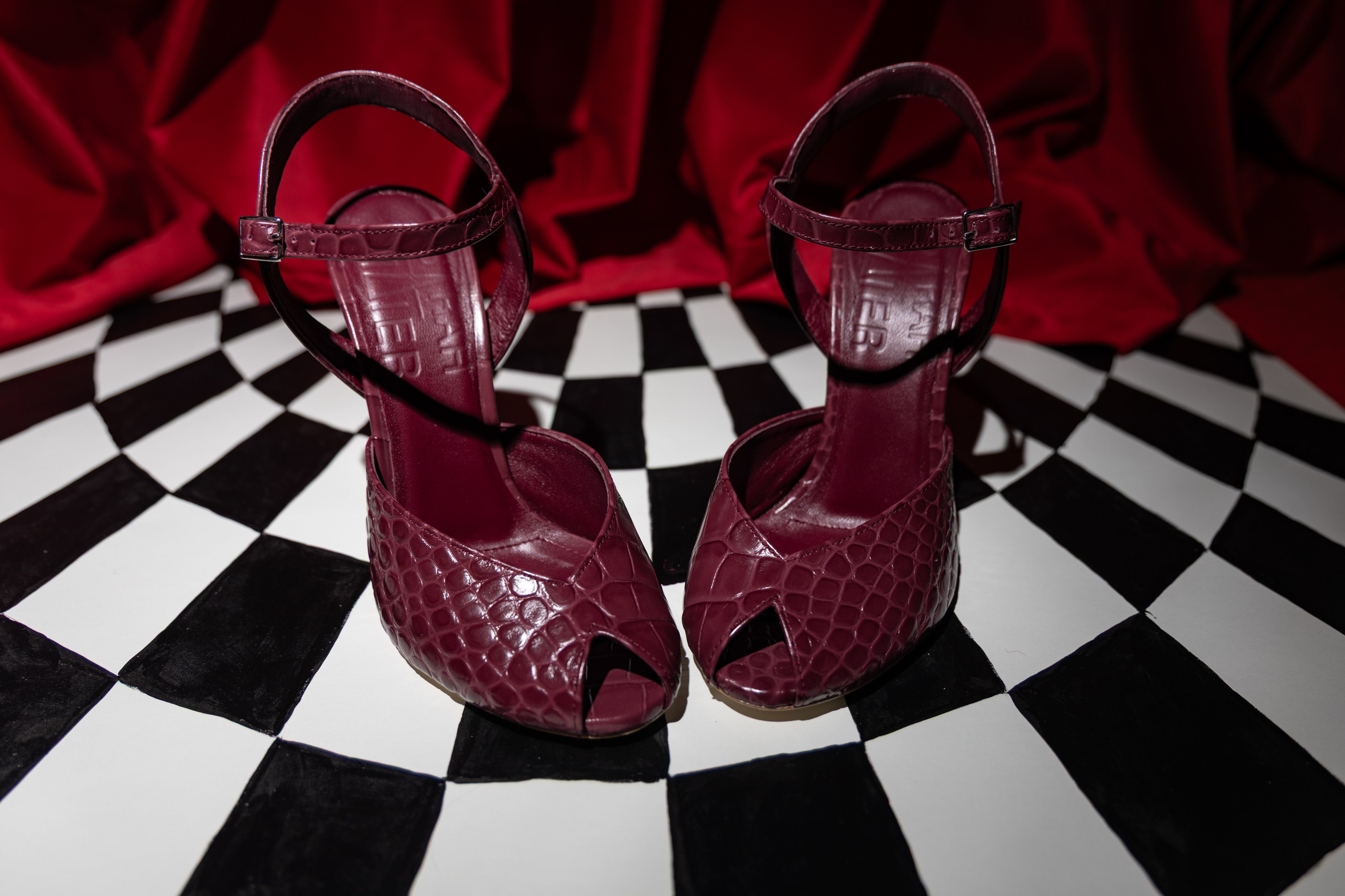 Siena Noire after dark, on a chequered floor against red