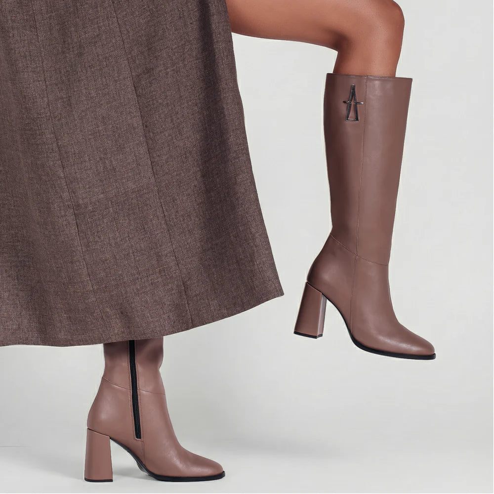 Taupe suede knee boots worn with a tailored skirt